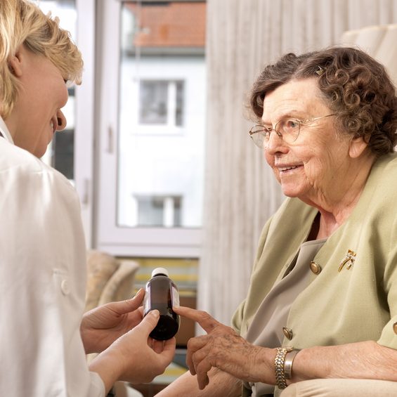 Doctor showing elderly patient medicine