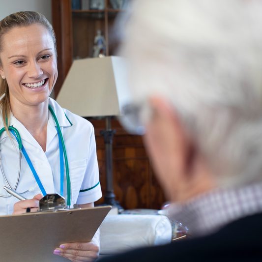 dreamstime_s_165308236 Female nurse doing a checkup making notes on an elderly patient